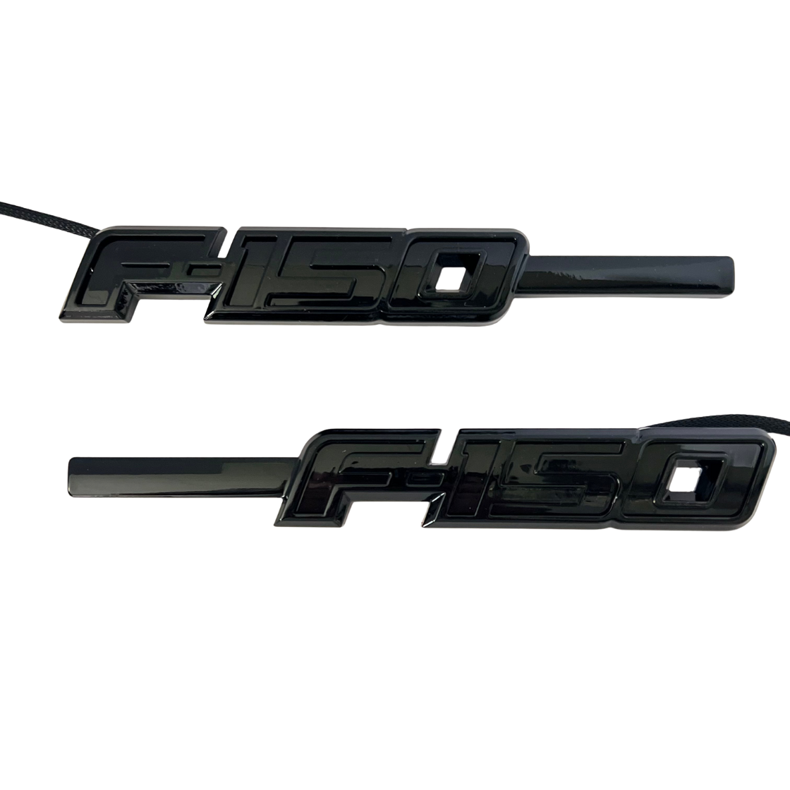 Pair of gloss black LED F-150 fender emblems with wiring, front view, on a white background.