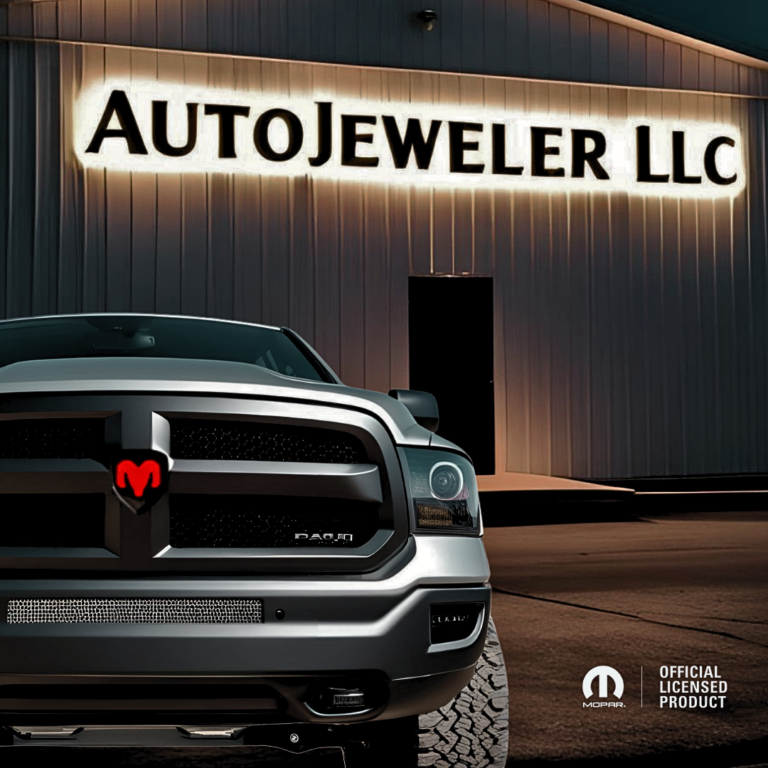 RAM truck with RGB illuminated grille emblem glowing red, parked at night in front of AutoJeweler LLC building with illuminated sign and Official Licensed Product logo