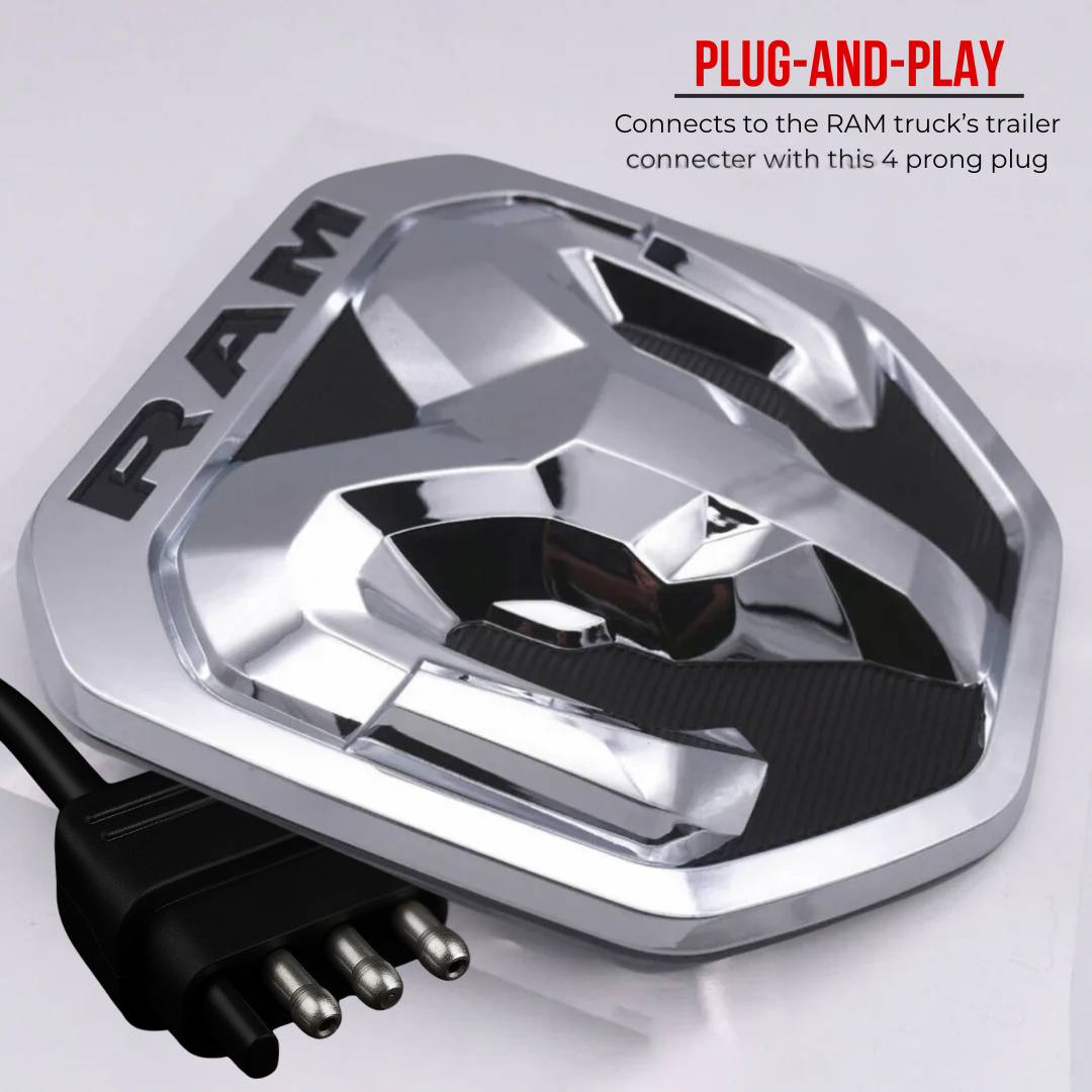 Close-up of the 2019–2024 RAM lighted chrome and black tailgate emblem showing the 4-pin plug-and-play trailer connector.