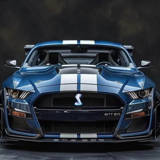 Front view of blue Ford Mustang Shelby GT500 with white racing stripes and white-glowing AutoJeweler RGBW Cobra grille emblem installed