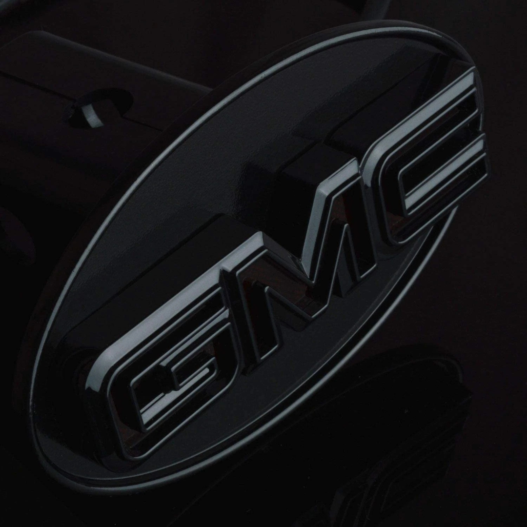 Detailed close-up of gloss black GMC LED hitch cover showing raised lettering and smooth black finish surface