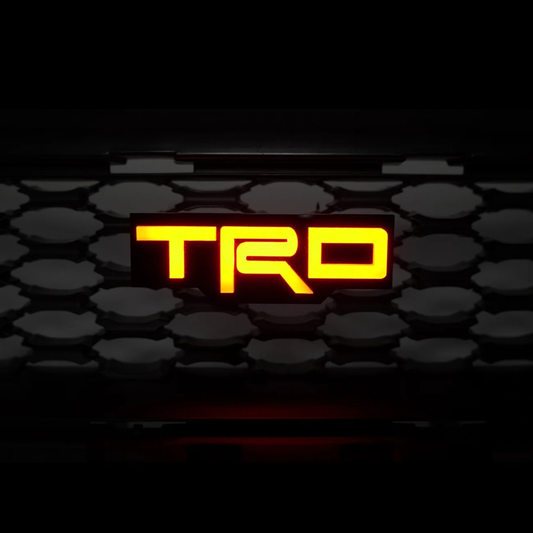 TRD Flow Series RGB LED grille emblem illuminated in orange