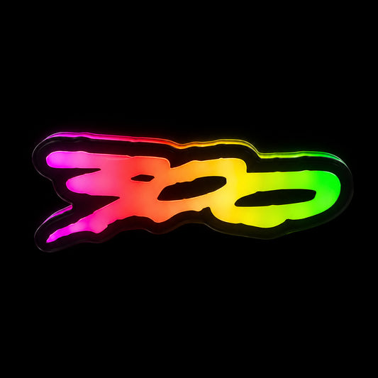 Flow Series 300 V2 RGB LED grille badge glowing pink, orange, yellow and green against a black background