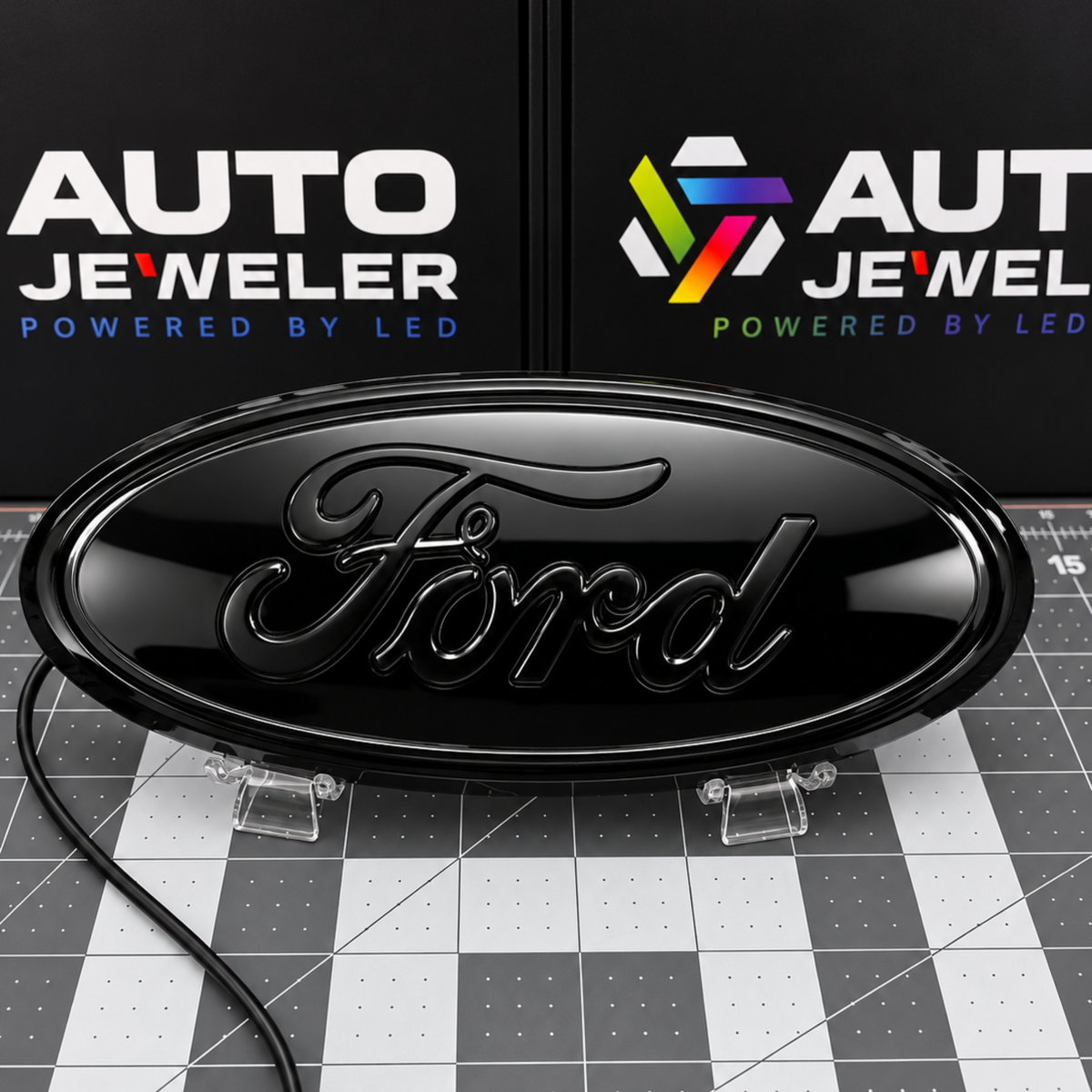AutoJeweler Gloss black Ford 9-inch dynamic LED grille and tailgate badge with black Ford script shown with the LEDs off.
