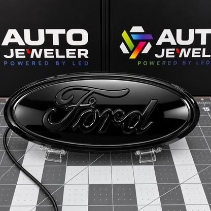 AutoJeweler Gloss black Ford 9-inch dynamic LED grille and tailgate badge with black Ford script shown with the LEDs off.