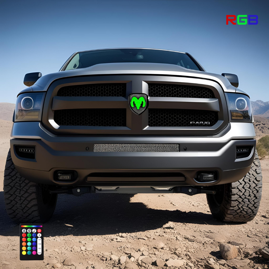 Black RAM truck with RGB illuminated grille emblem glowing green, parked on desert terrain with clear blue sky, RGB logo and remote control visible