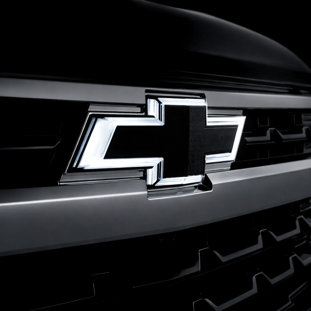 All black LED Chevy bowtie grille emblem with white illumination installed on a 2016–2018 Chevrolet Silverado 1500 front grille