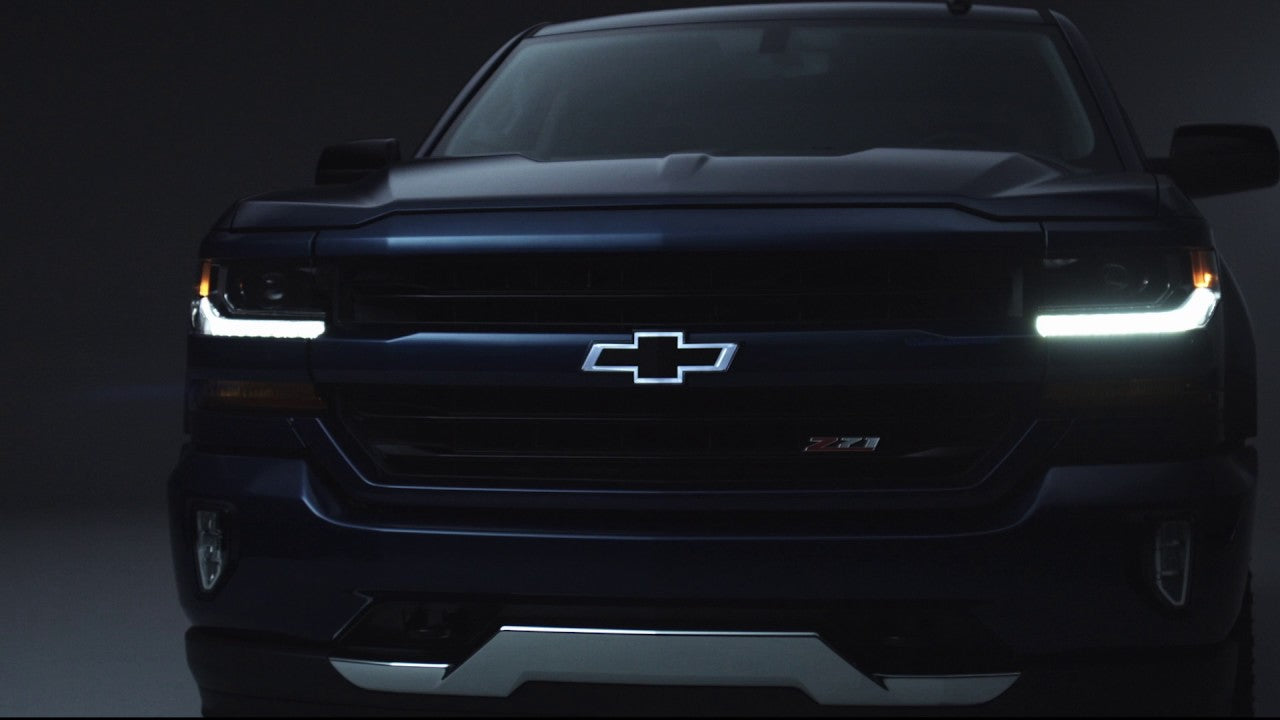 Chevrolet truck front view with illuminated logo on a dark background