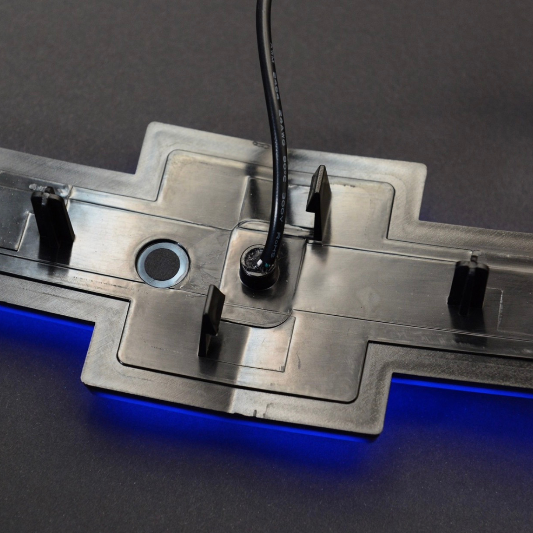 Close-up of the RGB emblem wiring and mounting clips with blue backlight.