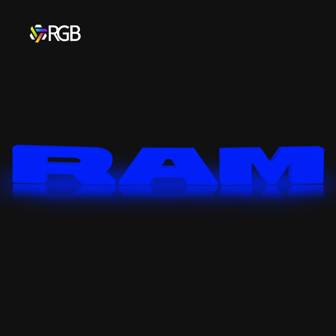 RAM 1500 black RGB LED grille emblem illuminated in blue, glowing effect on black background, AutoJeweler RGB branding