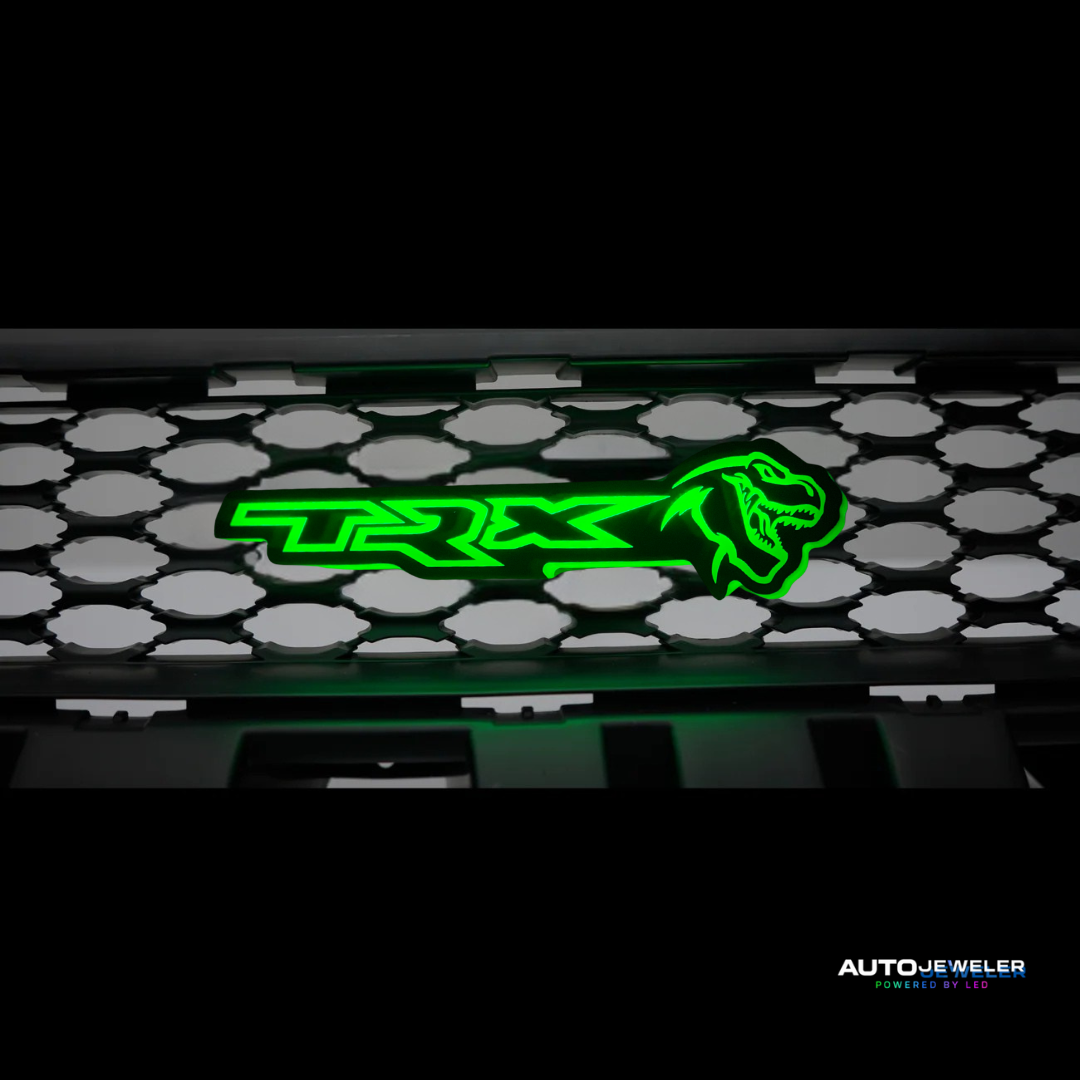 Green 'TRX' logo on a car grille with 'AUTO-JEWELER' branding.
