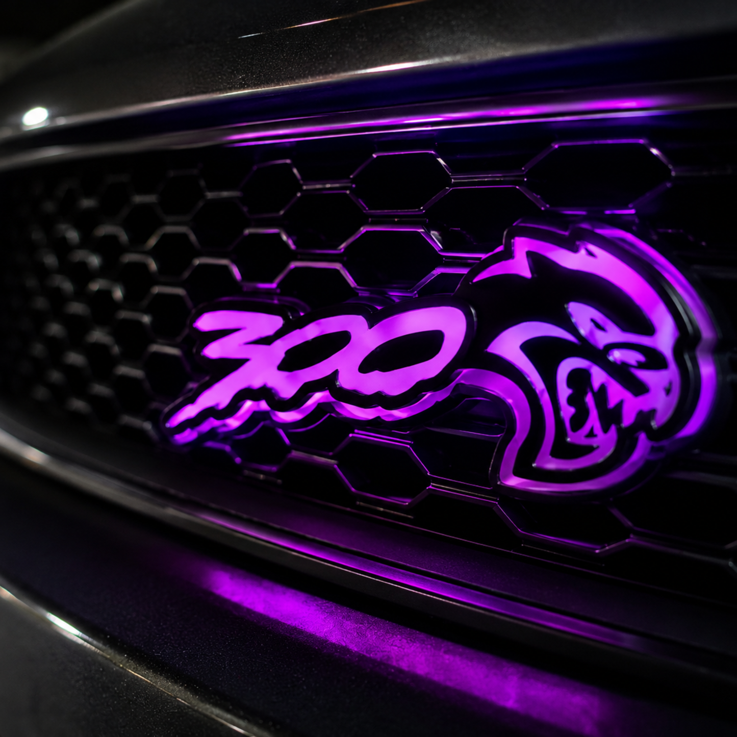 Chrysler 300 Hellcat V2 style light up grille emblem badge installed close up glowing bright purple.