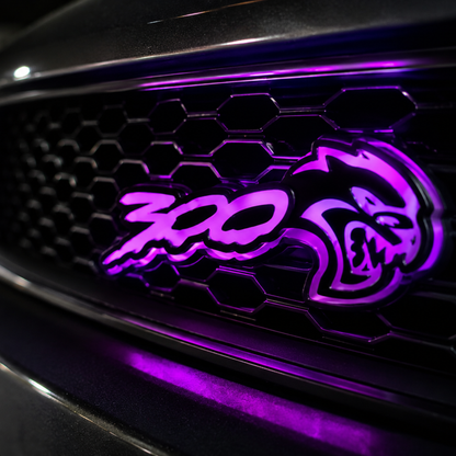 Chrysler 300 Hellcat V2 style light up grille emblem badge installed close up glowing bright purple.