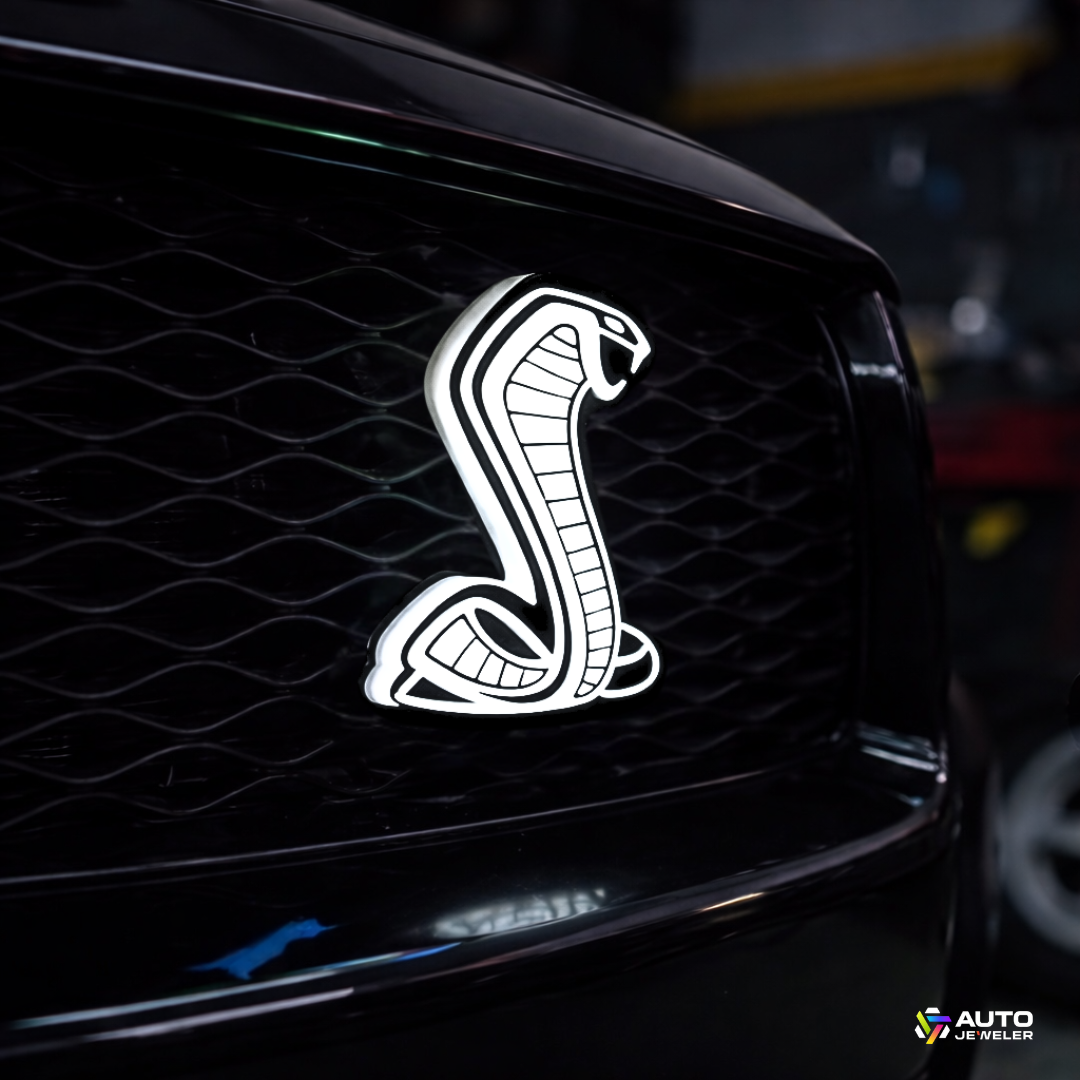 AutoJeweler Cobra LED Light-Up Grille Emblem installed on Ford Mustang grille with solid white LED illumination