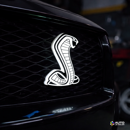 AutoJeweler Cobra LED Light-Up Grille Emblem installed on Ford Mustang grille with solid white LED illumination