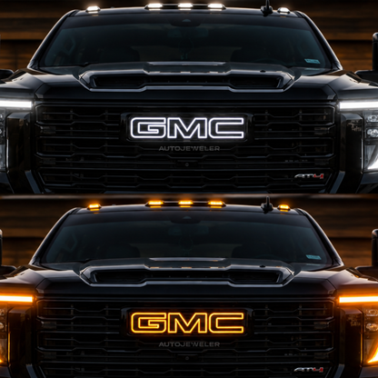 A front-facing view of a black GMC truck showing two lighting states of the  AutoJeweler 2019-2026 GMC Illuminated grille emblem: the top with the LED grille emblem illuminated in white, and the bottom with it illuminated in amber. The truck is set against a dark, blurred background.