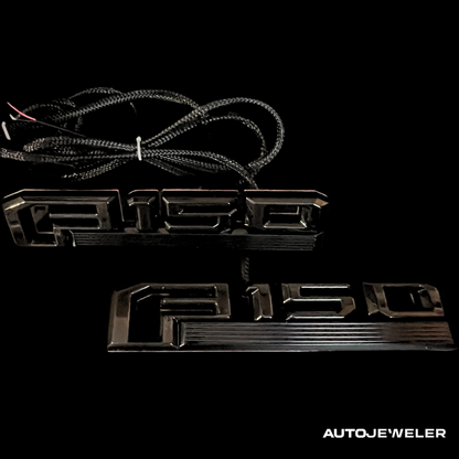 Black 'F150' LED fender emblem  kit with wiring on a black background, branded 'AUTOJEWELER'.