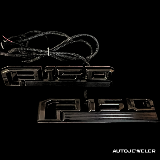 Black 'F150' LED fender emblem  kit with wiring on a black background, branded 'AUTOJEWELER'.