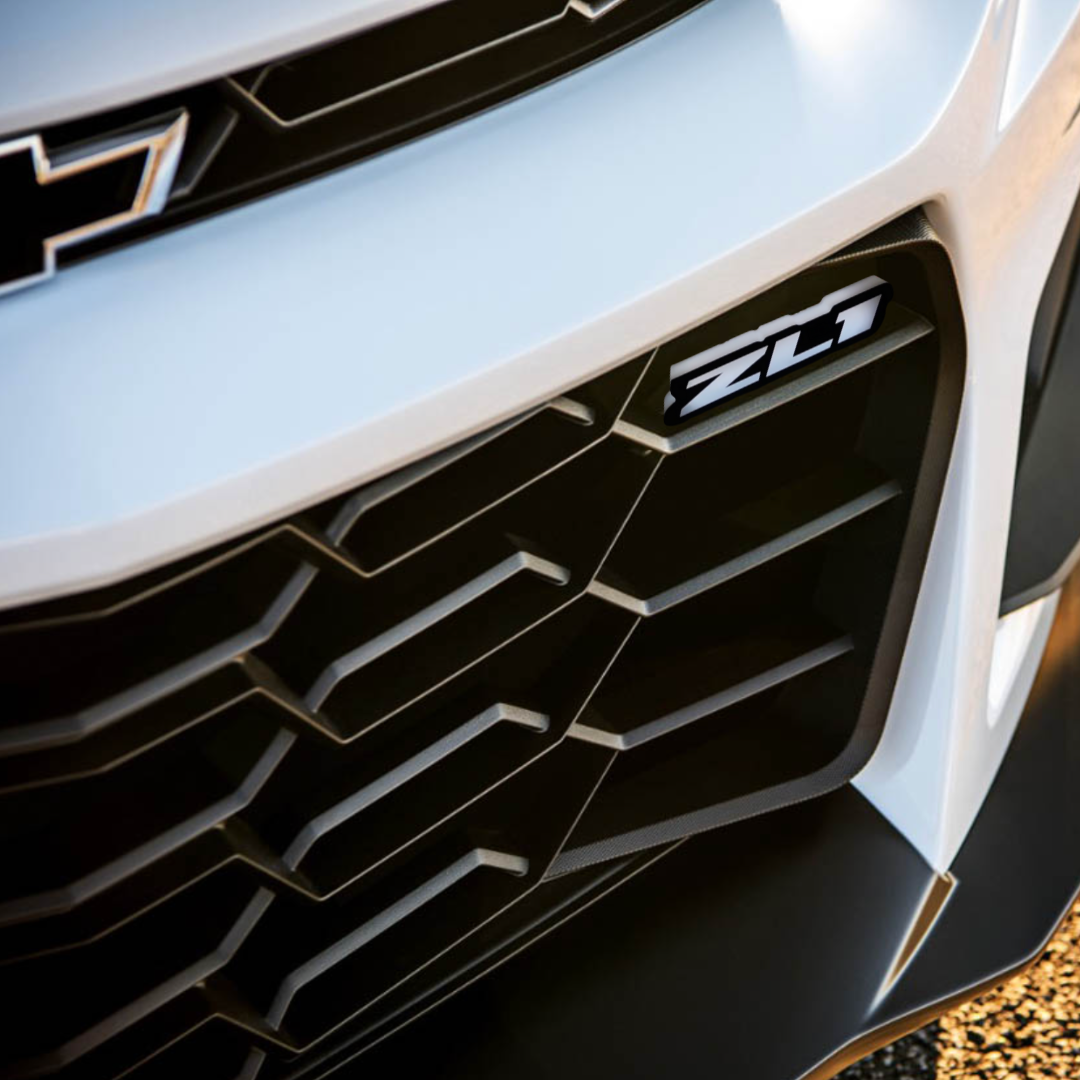 ZL1 LED emblem badge installed on white Camaro grille – daytime view showing OEM-style fitment by AutoJeweler.