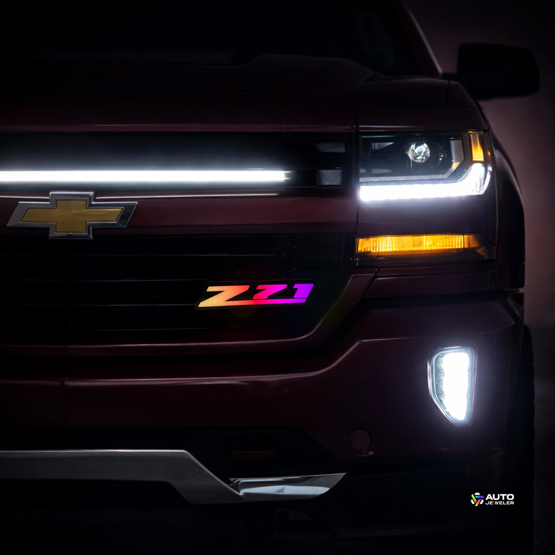 Chevy Silverado front grille at night with Z71 RGB Flow Series LED grille badge installed and flowing multicolor lighting