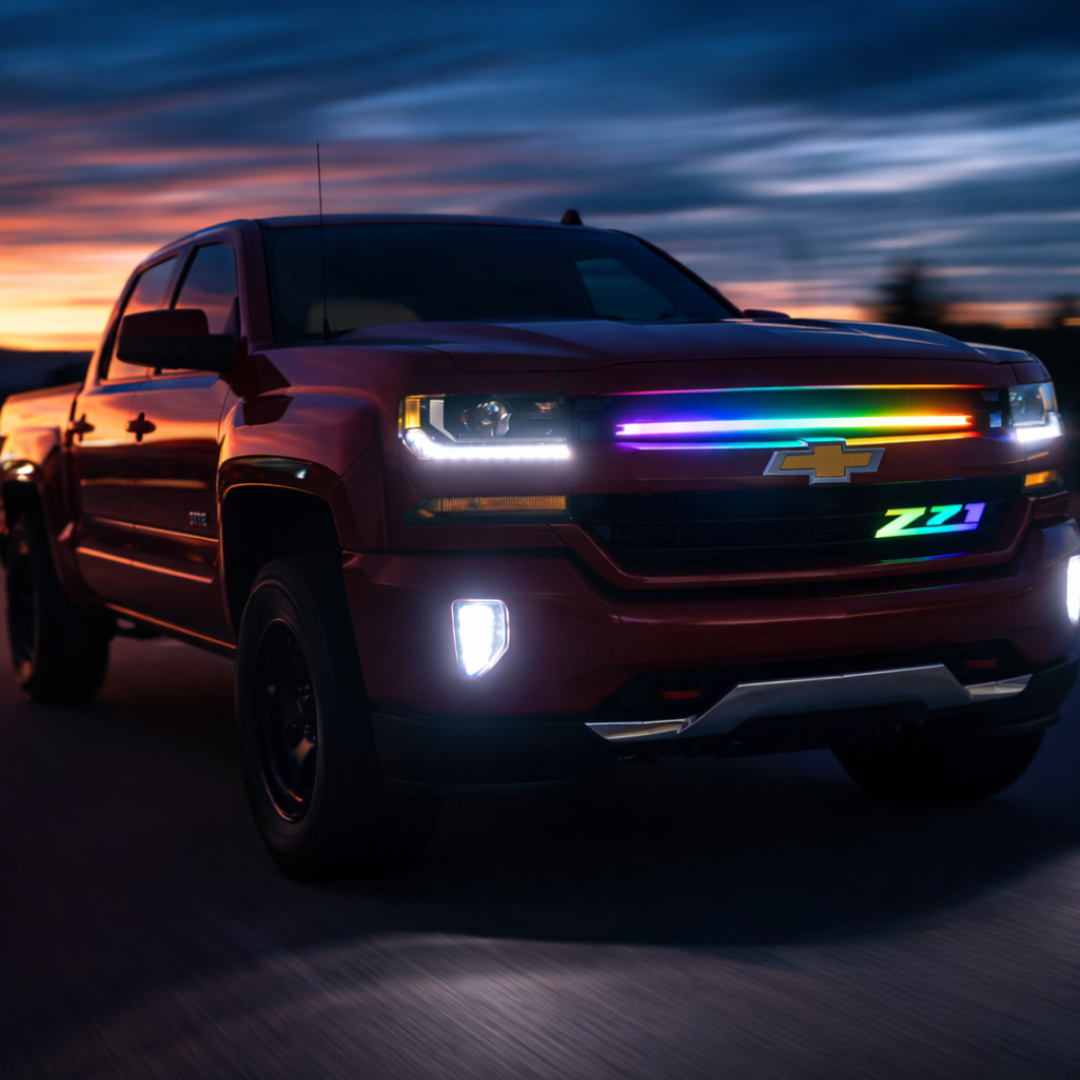 Chevy Silverado driving at sunset with Z71 RGB Flow Series LED grille badge installed and flowing multicolor lighting