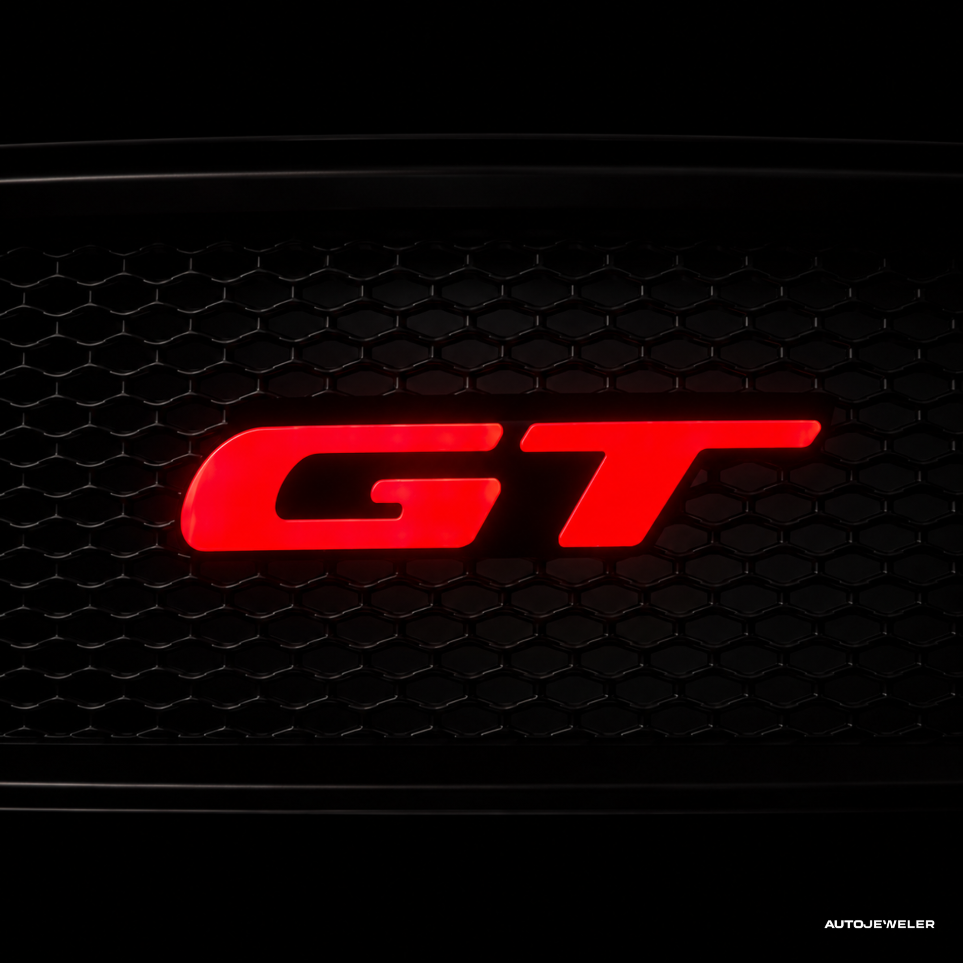 Red 'GT' logo on a black honeycomb grille for a Ford Mustang GT by AutoJeweler.