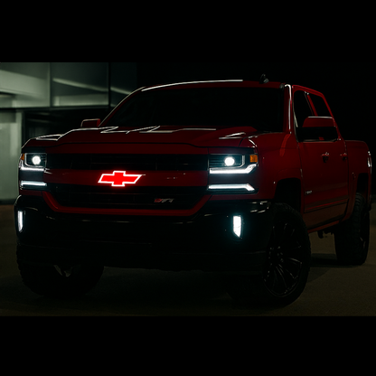 Red Chevrolet truck with illuminated logo in a dark setting