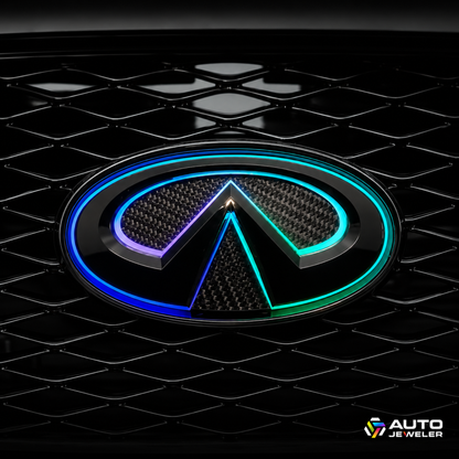 Close-up of the AutoJeweler 2018–2024 Infiniti Q50 V2 Flow Series LED grille emblem installed in the factory grille, featuring a gloss black housing, carbon fiber face, and animated blue and cyan multicolor lighting.