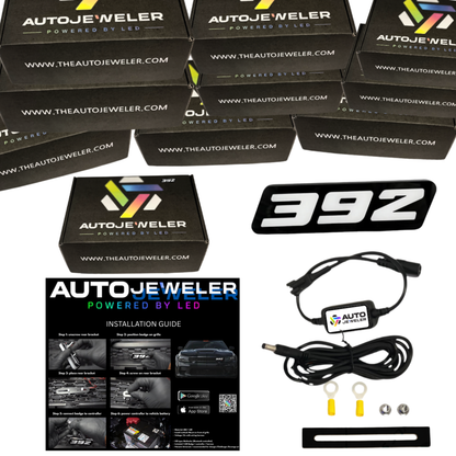 AutoJeweler 392 LED grille emblem kit with Bluetooth controller, wiring harness, hardware, install guide, and 10 products in stock with branded box on white background.