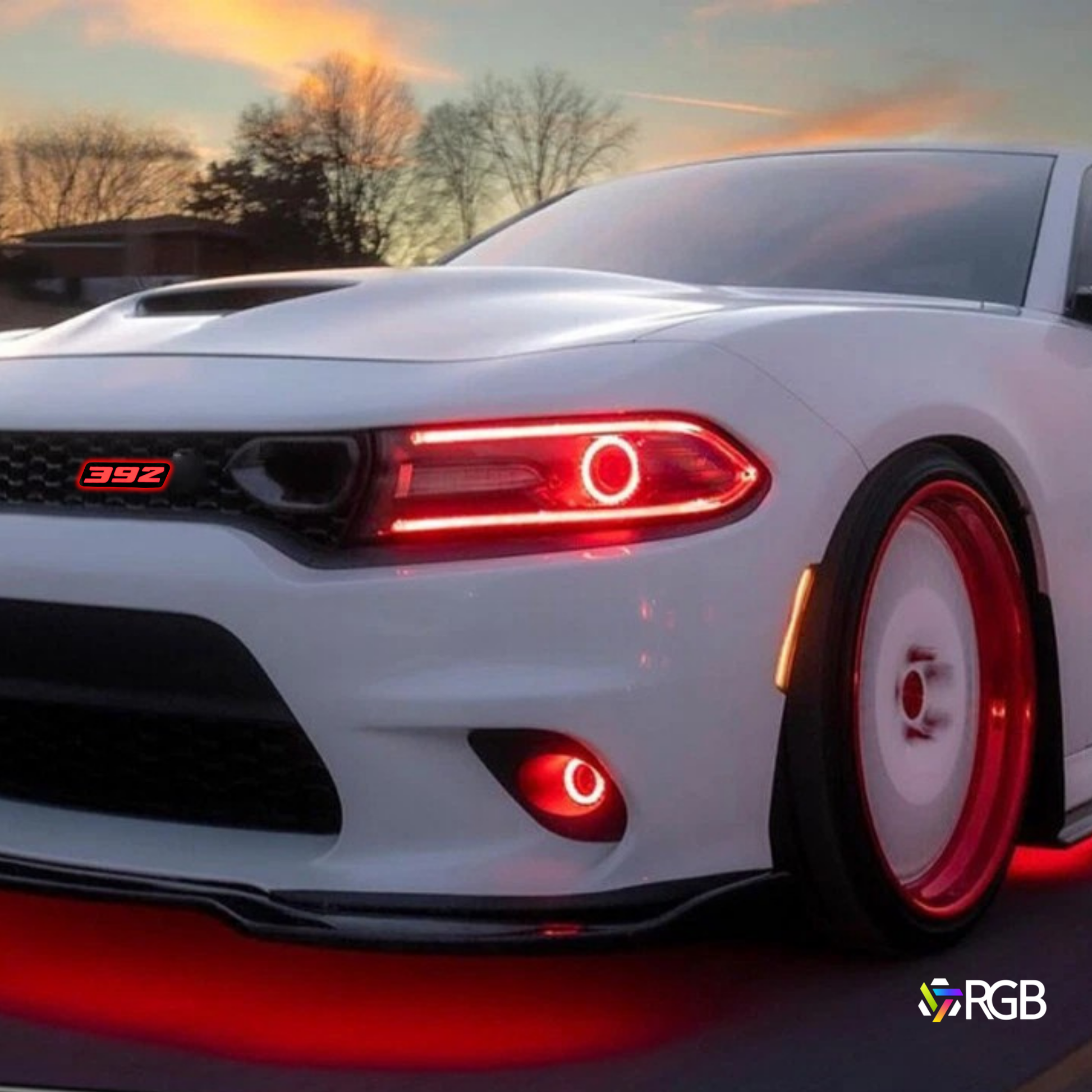 392 RGB Flow-Series LED grille emblem installed on Dodge Charger with red accent lighting at sunset – AutoJeweler.