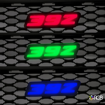 392 RGB Flow-Series LED grille emblem glowing red, green, and blue on a honeycomb grille – AutoJeweler.