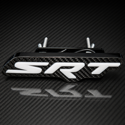 An LED  carbon fiber SRT badge with white 3D lettering, on a matching carbon fiber background.