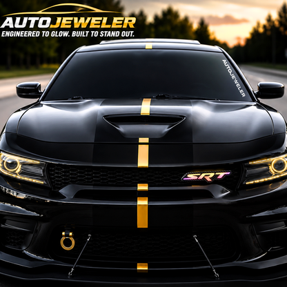 Black performance car with gold racing stripe and AutoJeweler carbon fiber SRT RGB grille emblem glowing multicolor.