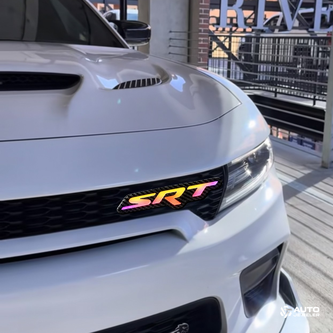 Premium Carbon Fiber SRT RGB LED grille emblem installed on a Dodge Charger daytime photo showing bright multicolor illumination