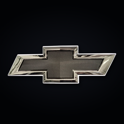 Chrome and black Chevrolet bowtie emblem with OEM-style textured black center on black studio background