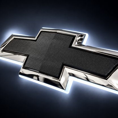 Close-up of chrome and black illuminated Chevy bowtie emblem with textured black center and white LED halo lighting