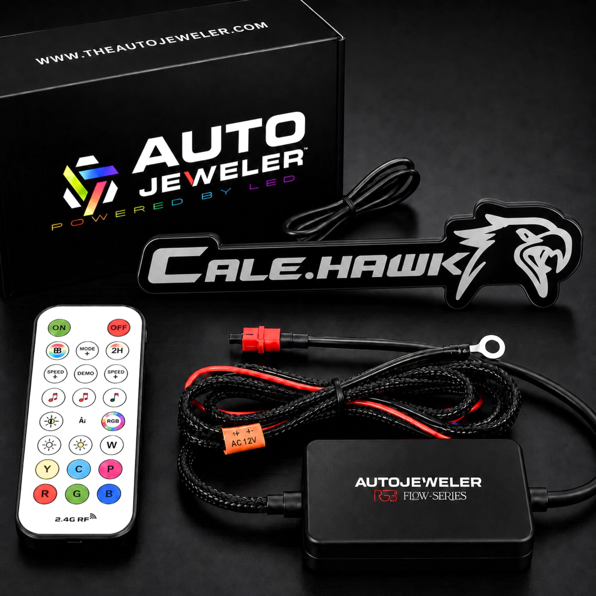 AutoJeweler custom RGB Flow Series badge kit contents with Cale Hawk emblem, RF remote, RGB controller, wiring harness, and branded packaging.
