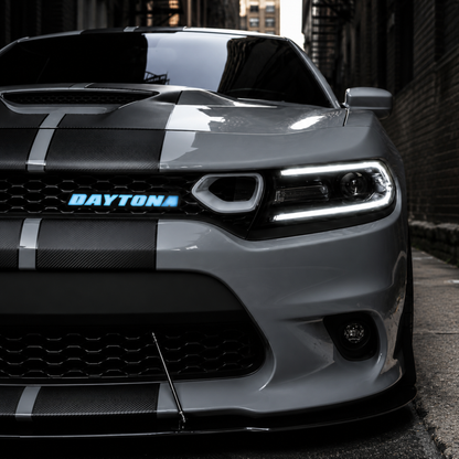 White Dodge Charger featuring illuminated blue Daytona LED grille emblem installed on front grille