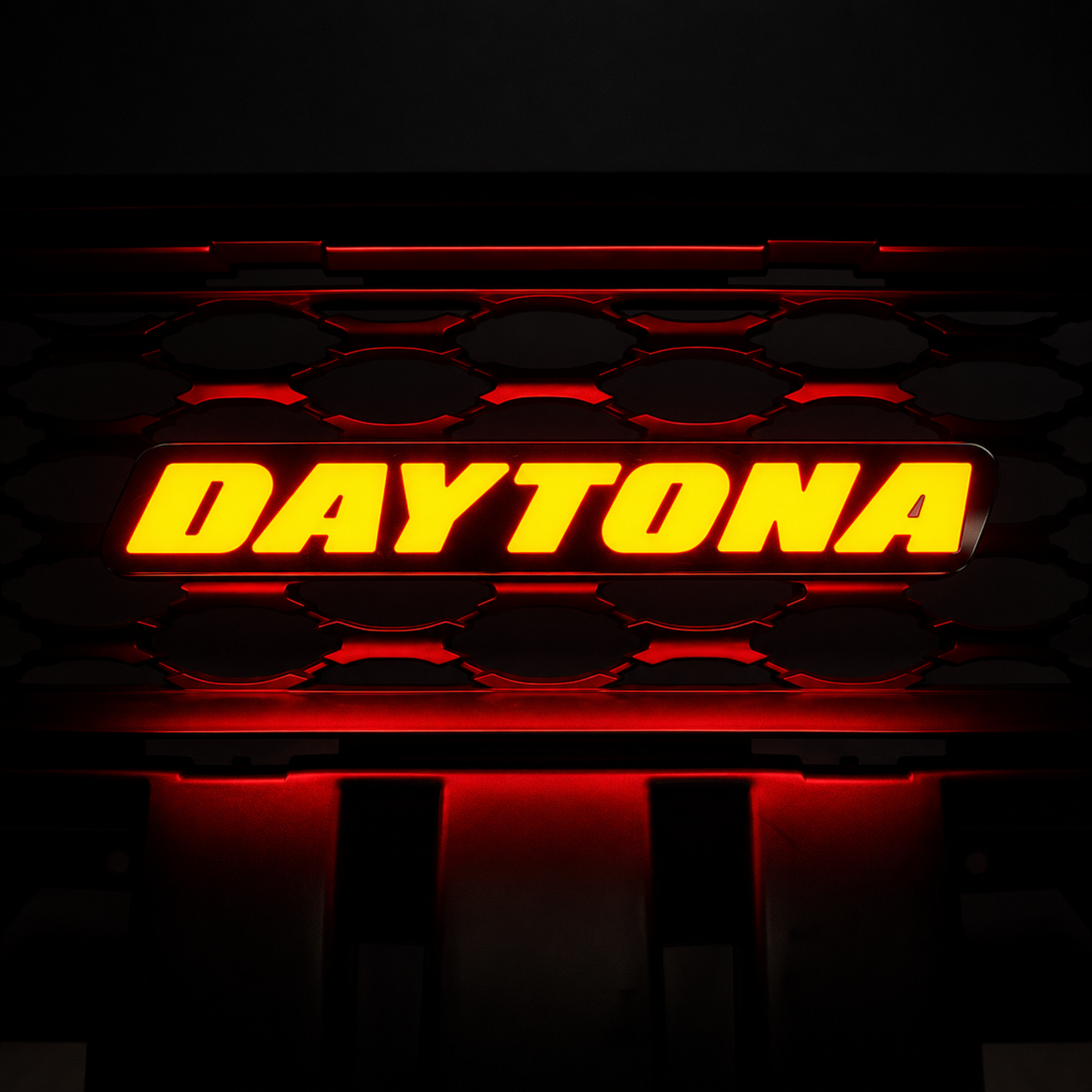 Daytona LED grille emblem illuminated in bright red lighting mode mounted on black honeycomb grille background