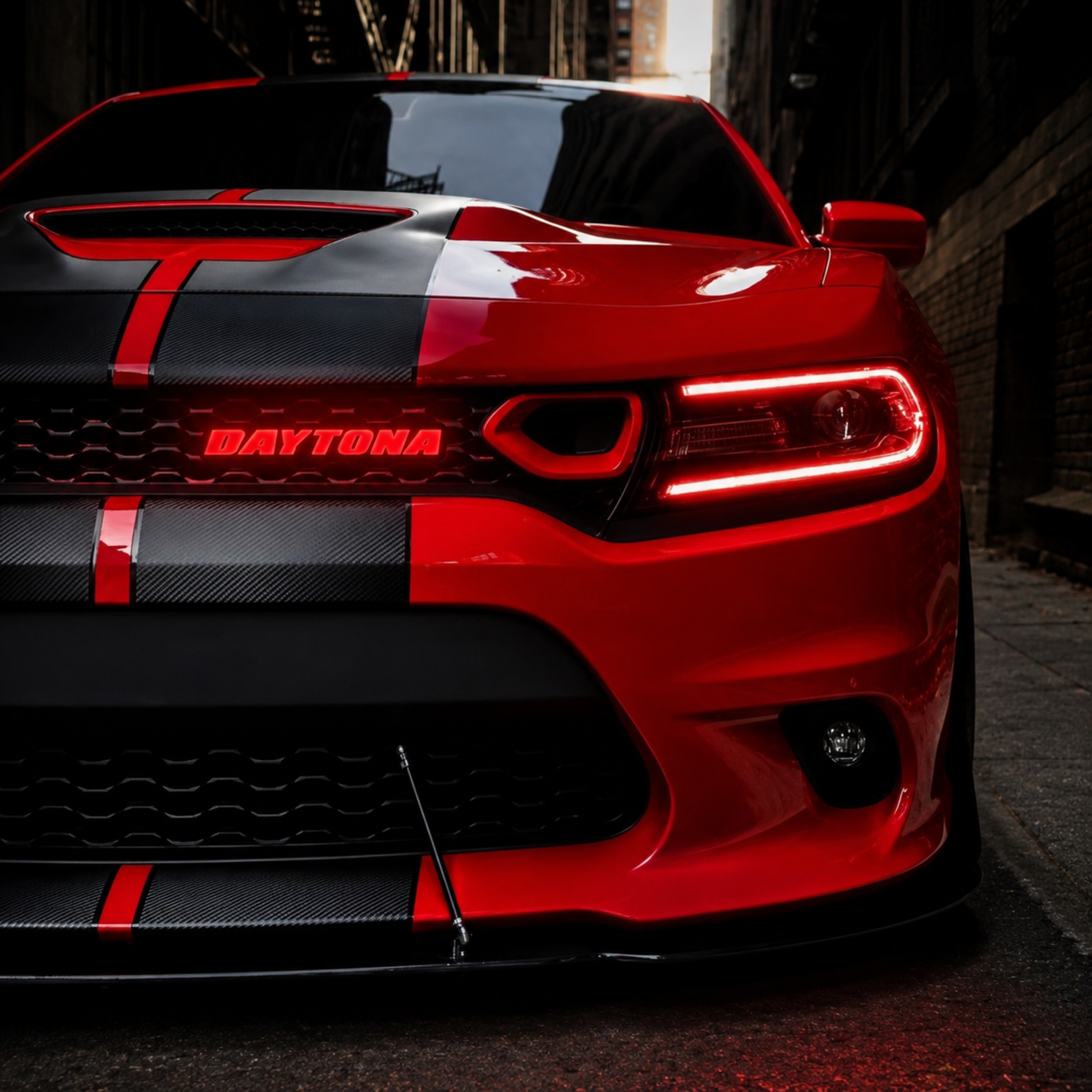 Red Dodge Charger with illuminated red Daytona LED grille emblem installed on front grille in urban street setting
