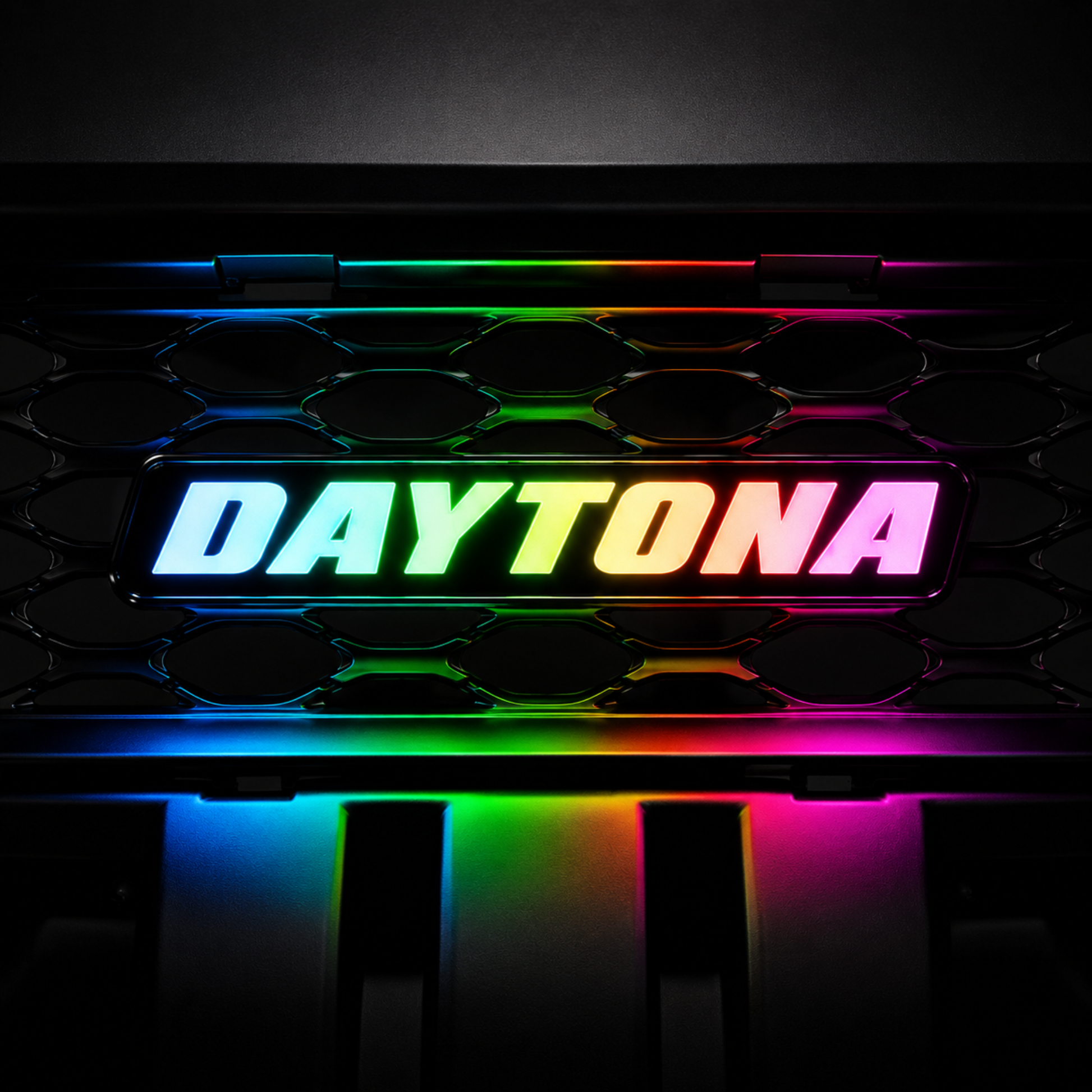 AutoJeweler Daytona RGB Flow Series LED grille emblem with rainbow multicolor lighting mounted on black honeycomb grille background