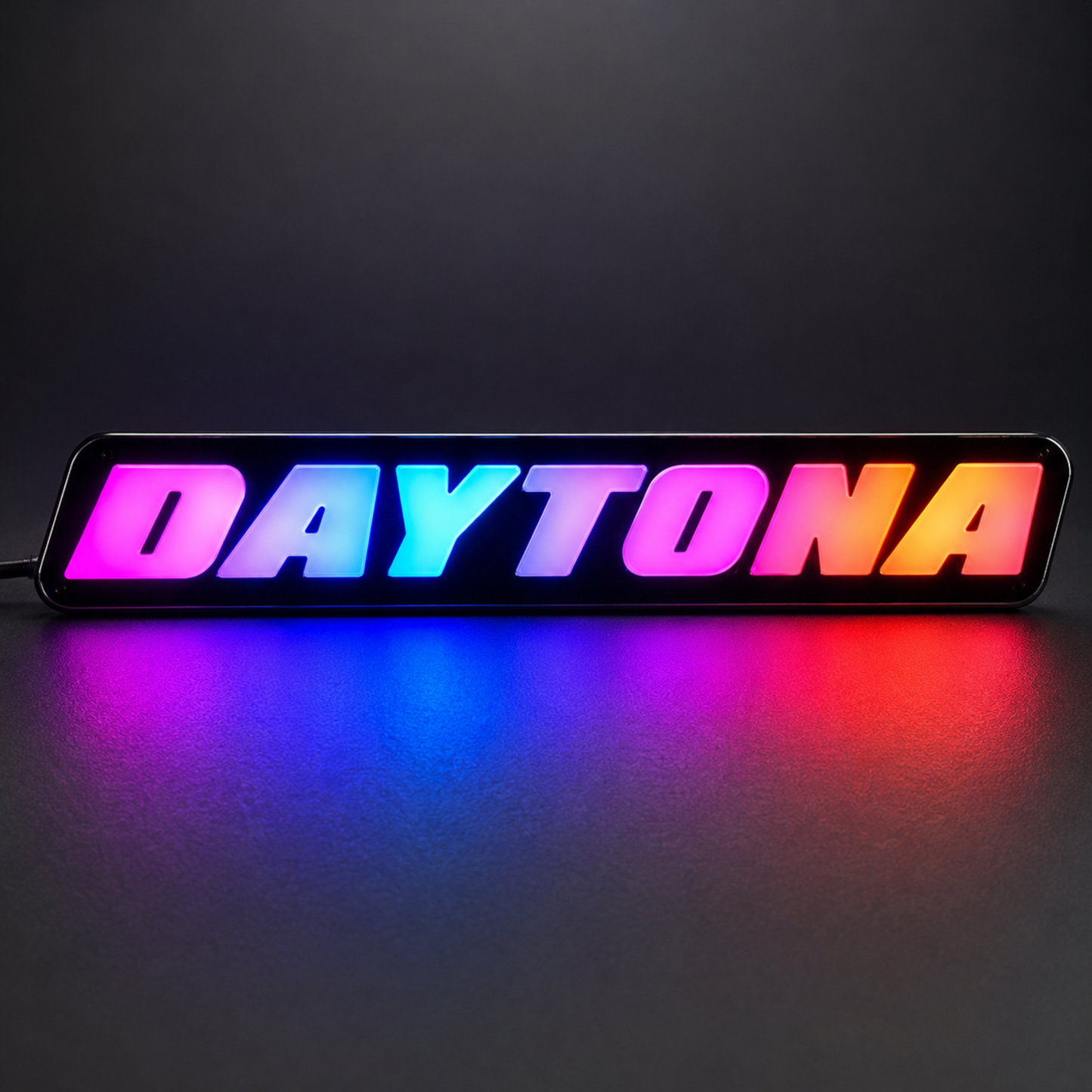 AutoJeweler Daytona RGB LED grille emblem with vibrant gradient lighting colors including pink blue orange and purple