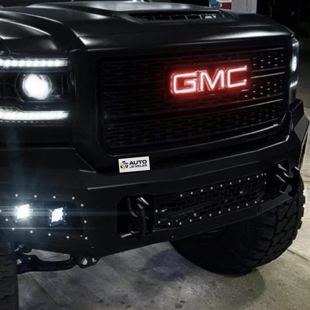 Red RGBW illuminated GMC grille emblem installed on black lifted GMC truck