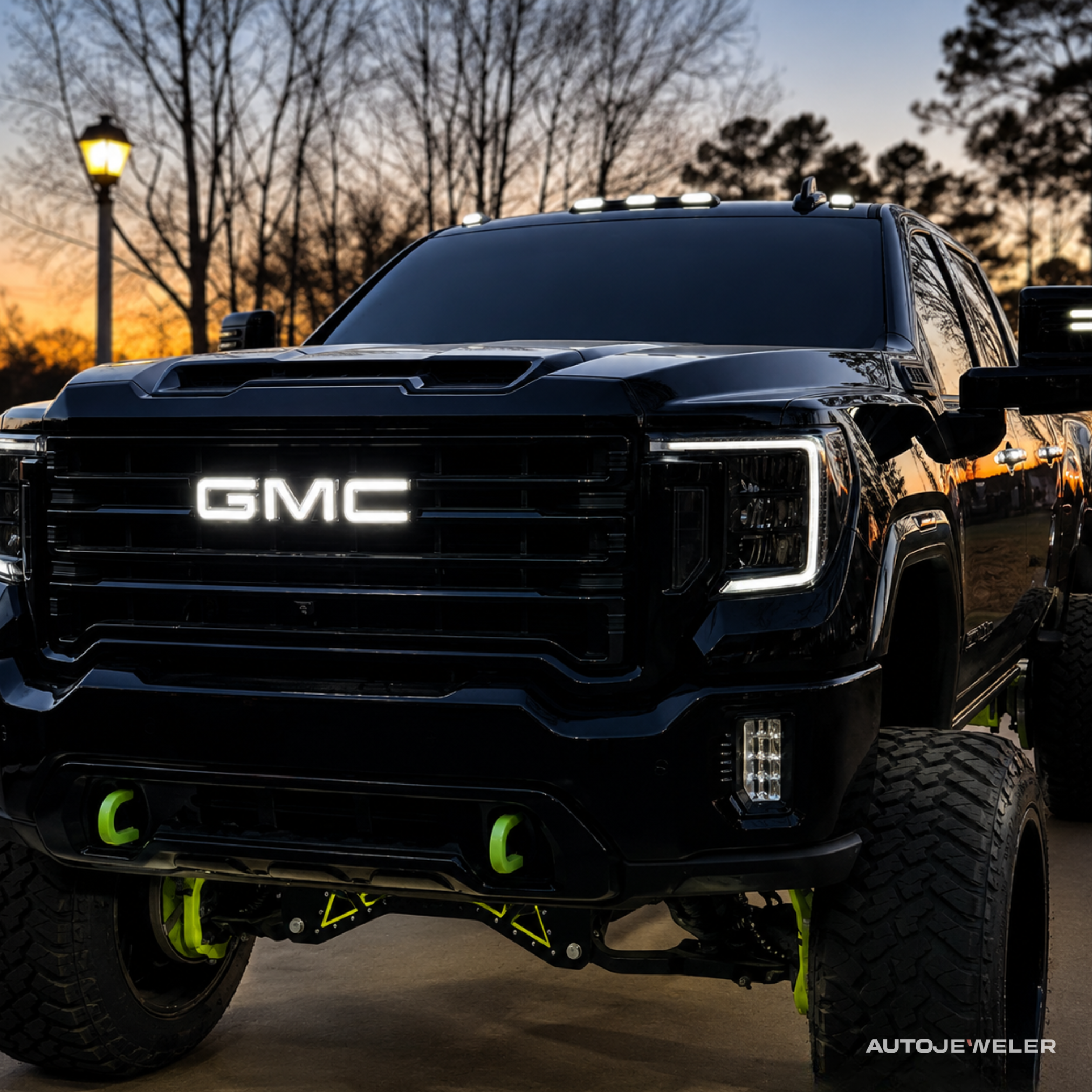 AutoJeweler RGBW GMC LED illuminated grille logo showing bright white output on a lifted GMC Sierra truck.