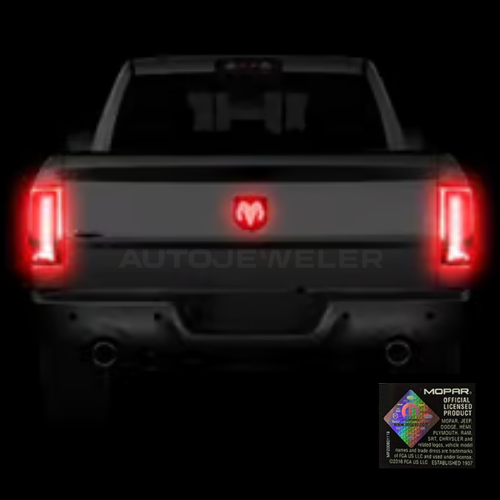 Nighttime rear view of RAM truck with AutoJeweler red LED tailgate emblem illuminated during braking.