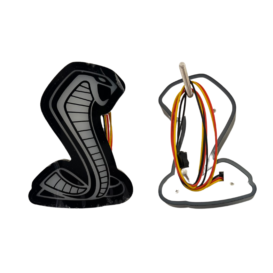 Front and back view of AutoJeweler RGBW Mustang Cobra grille emblem – shows wiring and mounting design