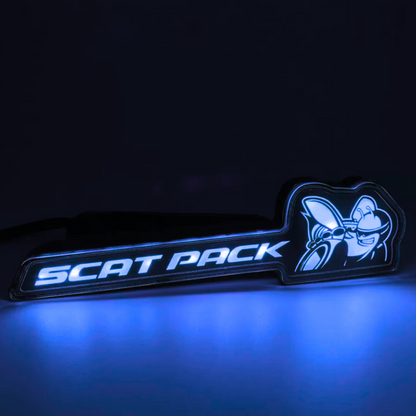 Scat Pack RGB Flow-Series LED grille emblem glowing blue on a black background – AutoJeweler product close-up.