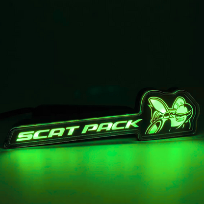 Scat Pack RGB Flow-Series LED grille emblem glowing green on a black background – AutoJeweler product close-up.