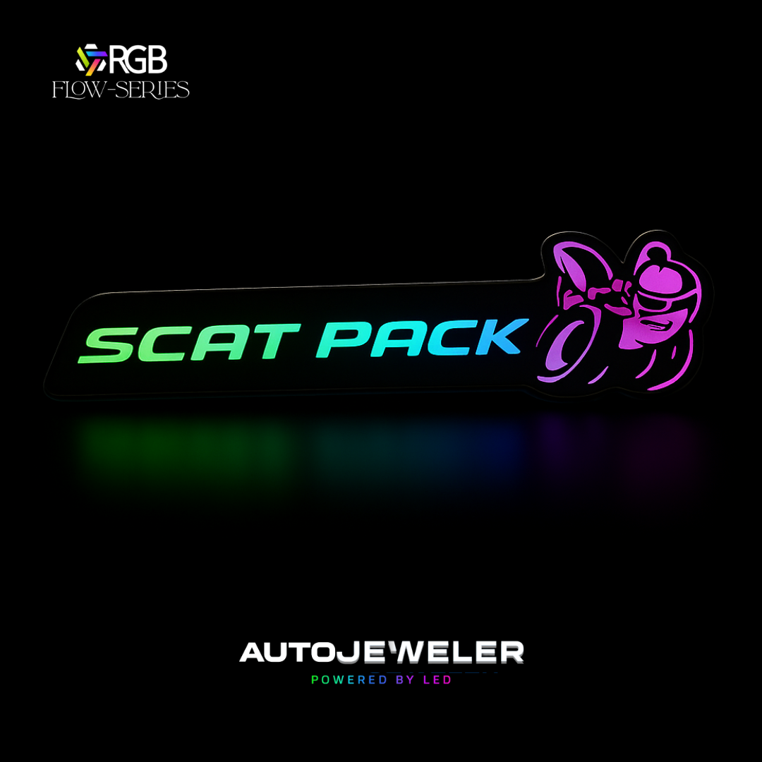 Scat Pack RGB Flow-Series LED grille emblem glowing in multicolor on a black background – AutoJeweler hero image