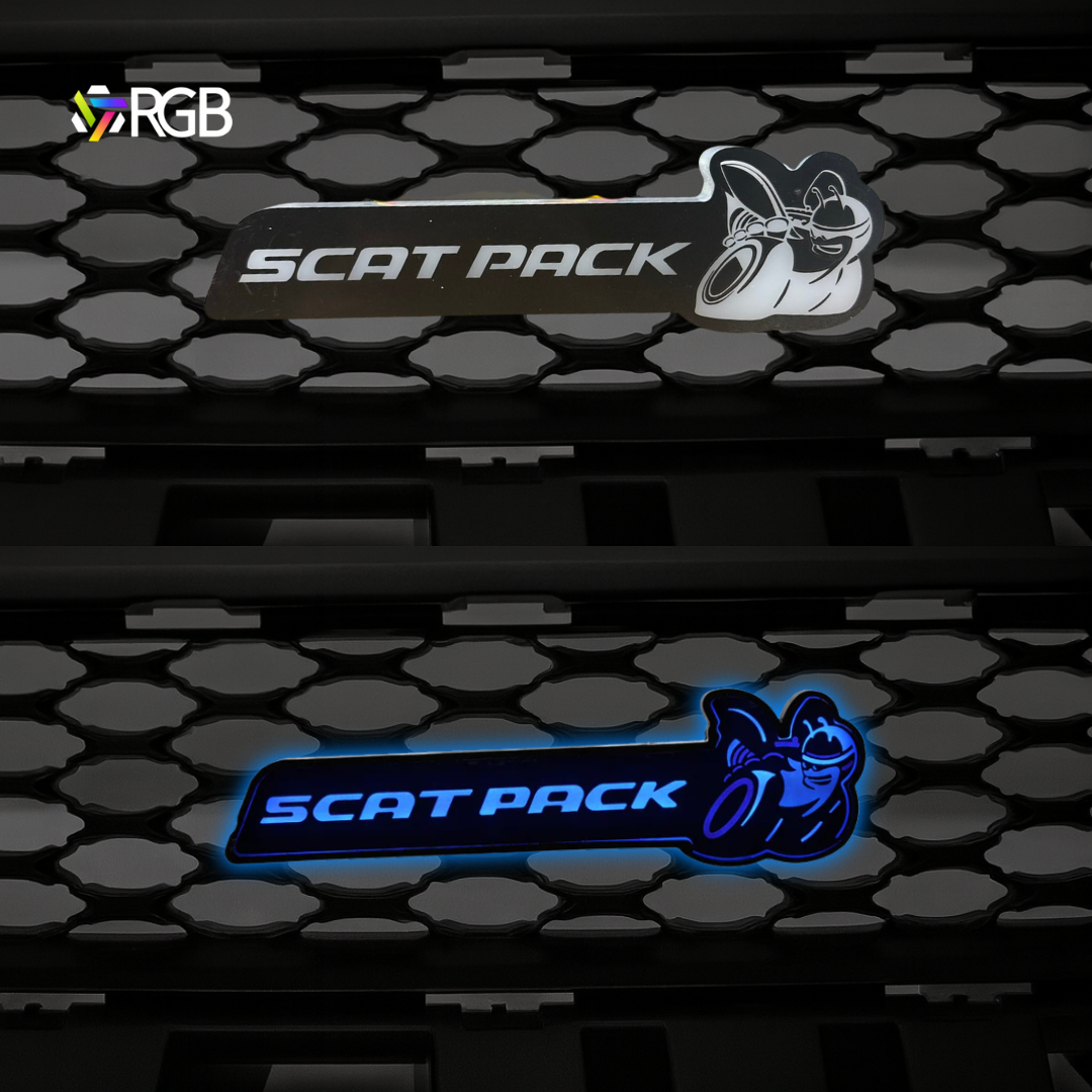 Side-by-side comparison of Scat Pack RGB Flow-Series LED grille emblem on a honeycomb grille—top unlit, bottom illuminated in blue—AutoJeweler.